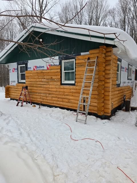 Straight half-log siding installed over a framed wall