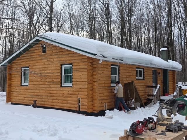 Finished half-log siding with saddle-notch corners on a Beaver log home